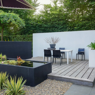 a stylish modern deck with plastic garden dining table and a rectangular pond with plants