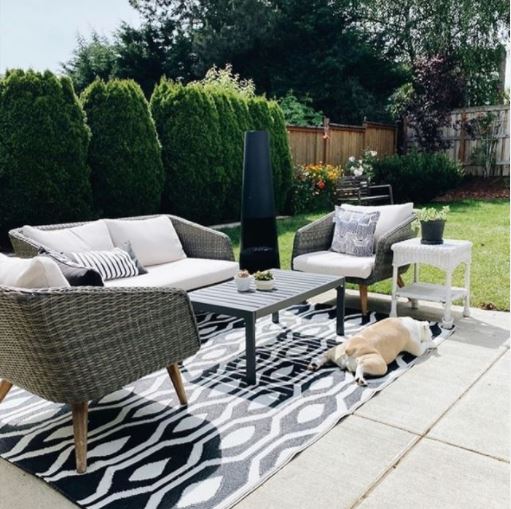 a concrete patio with an outdoor rug and patio furniture