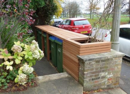 a contemporary bin store positioned so it's flush with the front garden wall