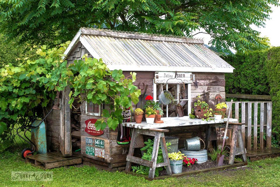 a rustic shed with workbench potting area outside and vintage signs as exterior decor