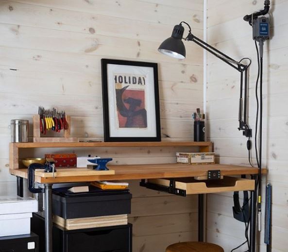 an outdoor workspace, with a small, neat desk area and anglepoise lamp