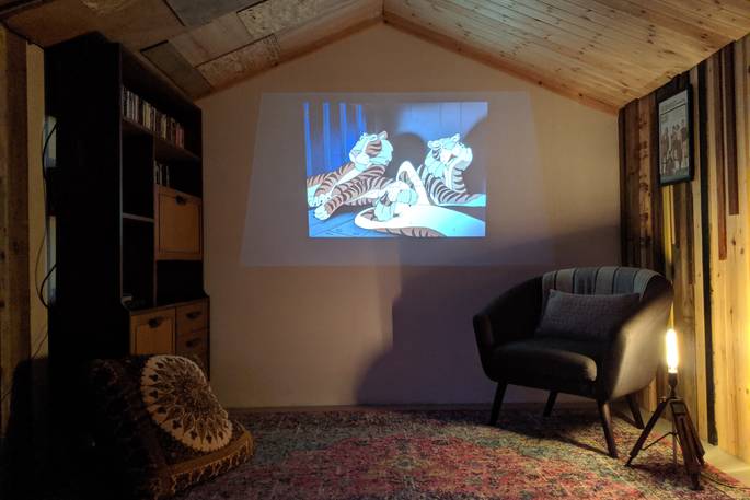 inside a garden man cave with a projector, playing an animated film