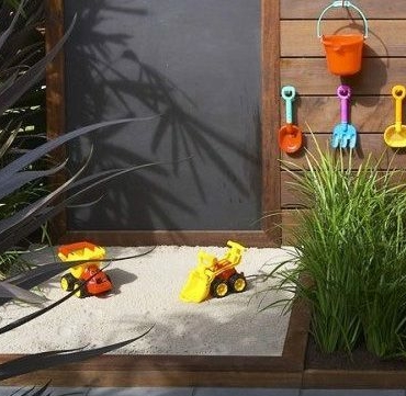 an outdoor sand pit and chalk board for children