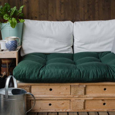 two wooden pallets stacked make a chair with a squashy cushion on top