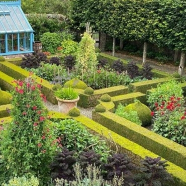 a beautiful, symmetrical kitchen garden with box hedge borders